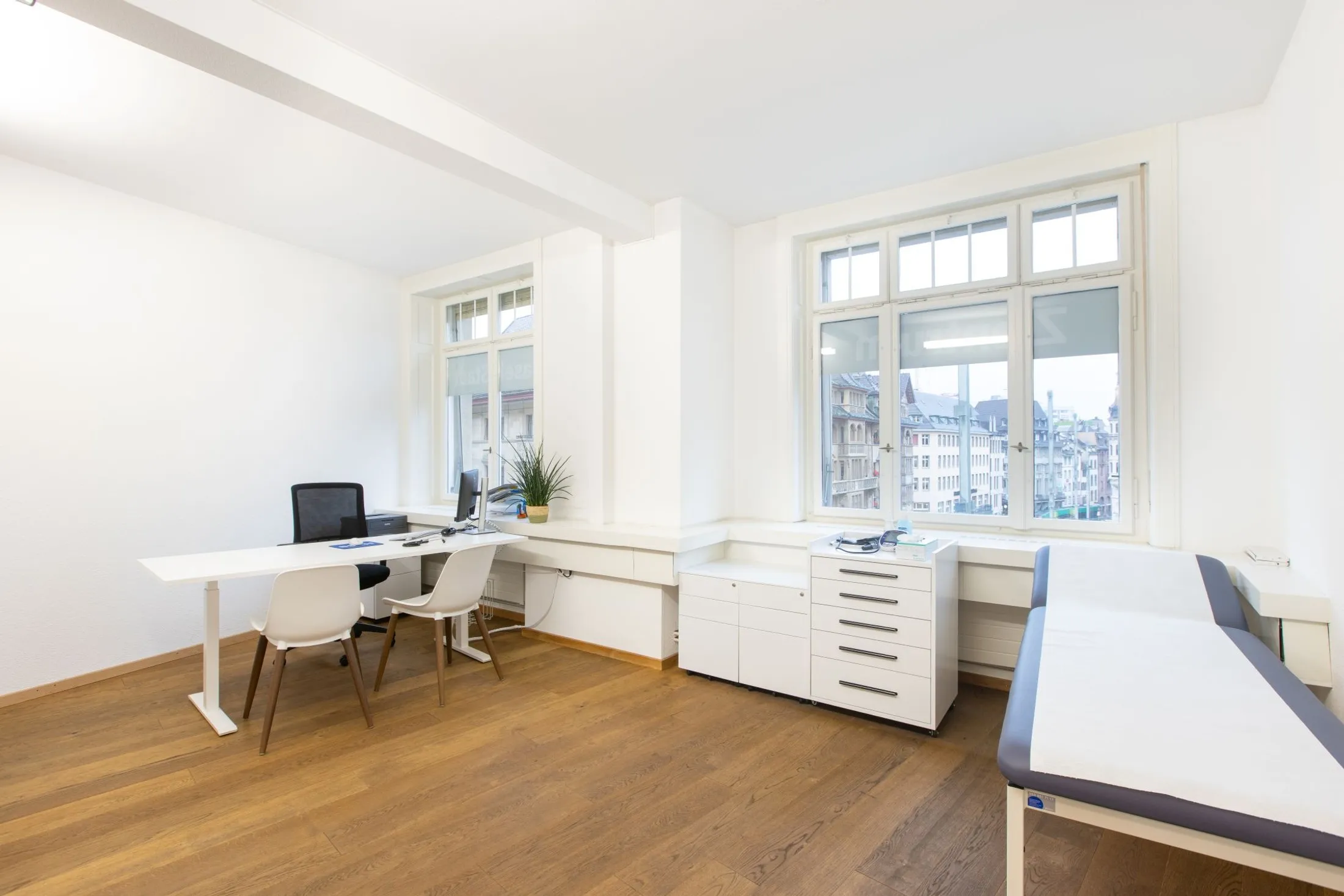 Sprechzimmer mit Arbeitsplatz und Untersuchungsliege
